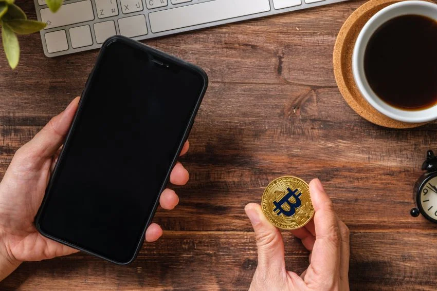  Hand holding mobile and bitcoin crypto currency 